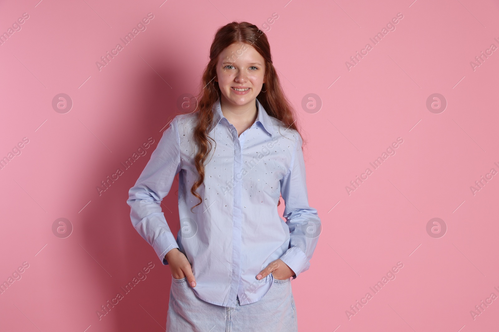 Photo of Happy teenage girl posing on pink background