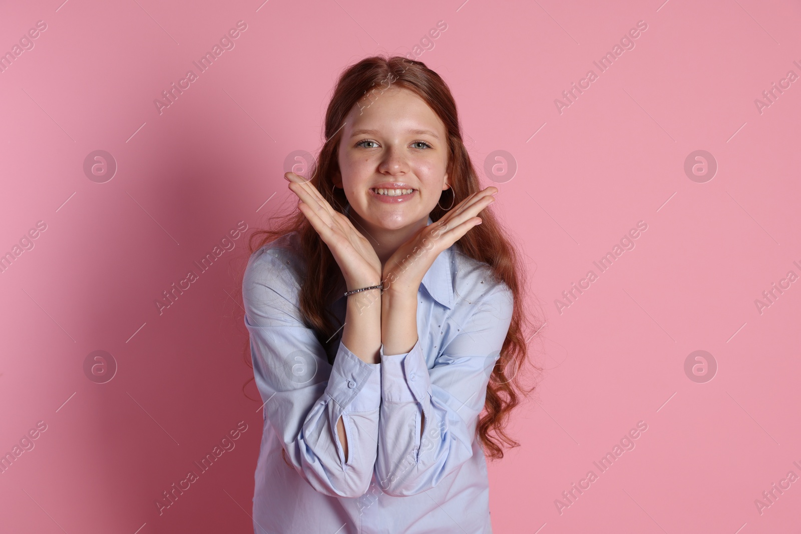 Photo of Happy teenage girl posing on pink background