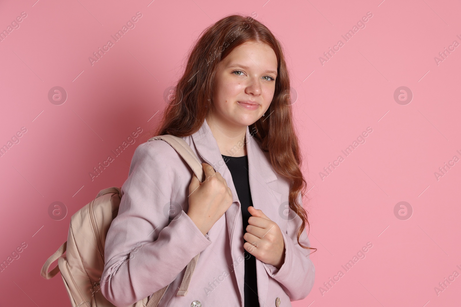 Photo of Cute teenage girl with backpack on pink background