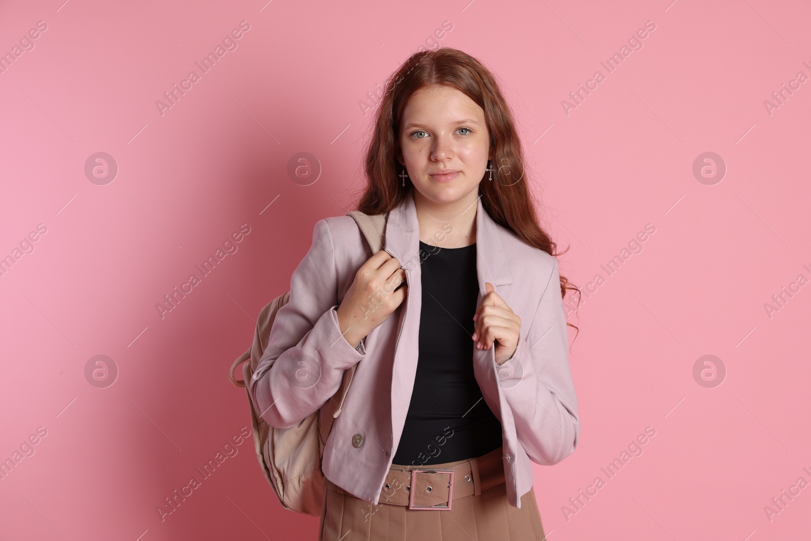 Photo of Cute teenage girl with backpack on pink background