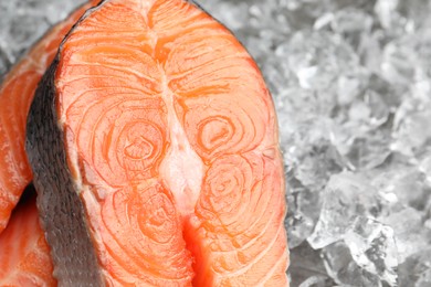 Photo of Fresh raw salmon steaks on ice pieces, closeup