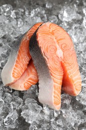 Photo of Fresh raw salmon steaks on ice pieces, closeup