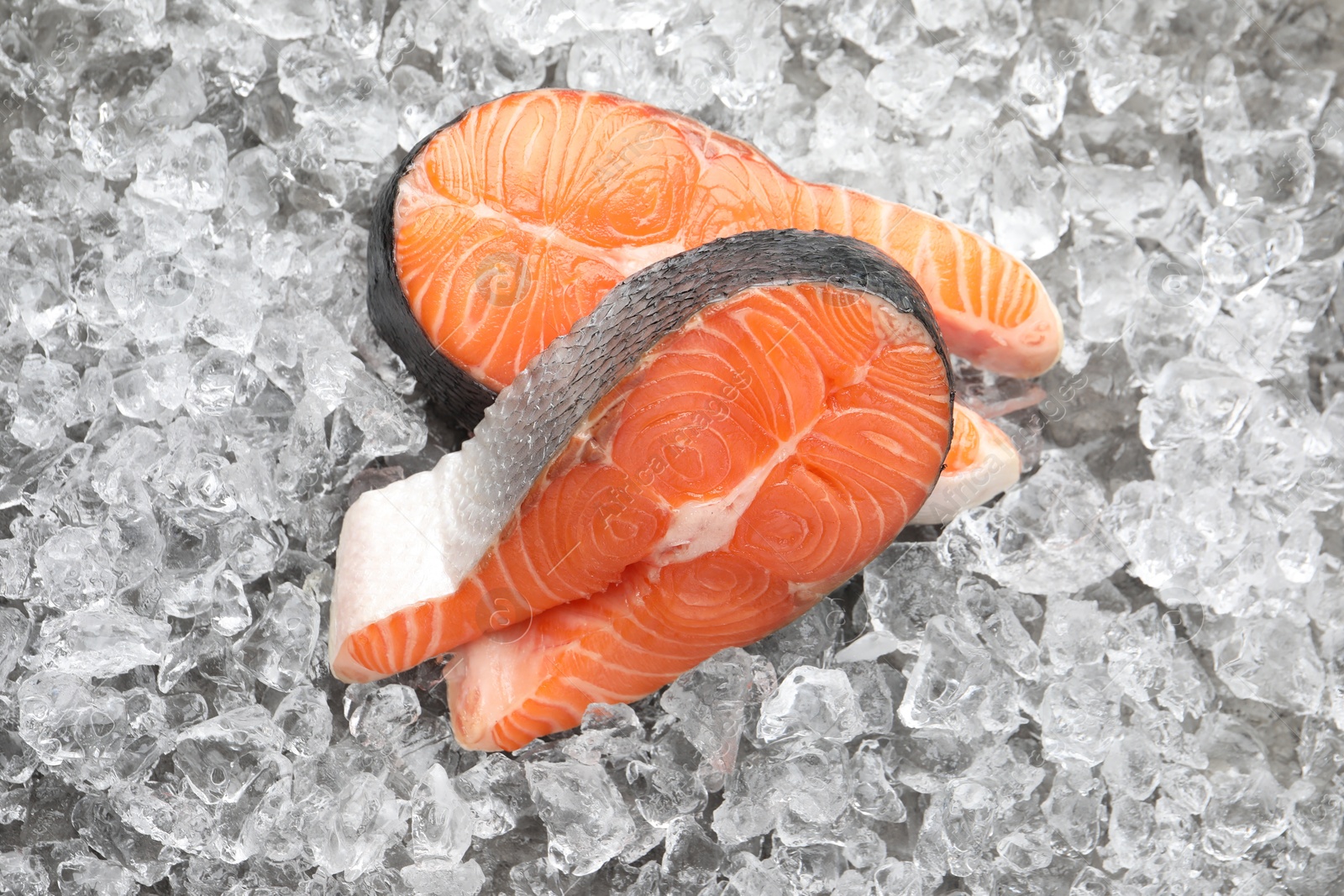 Photo of Steaks of fresh raw salmon on ice pieces