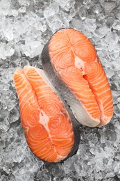 Photo of Fresh raw salmon steaks on ice pieces, top view