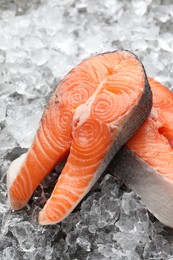 Photo of Fresh raw salmon steaks on ice pieces, closeup