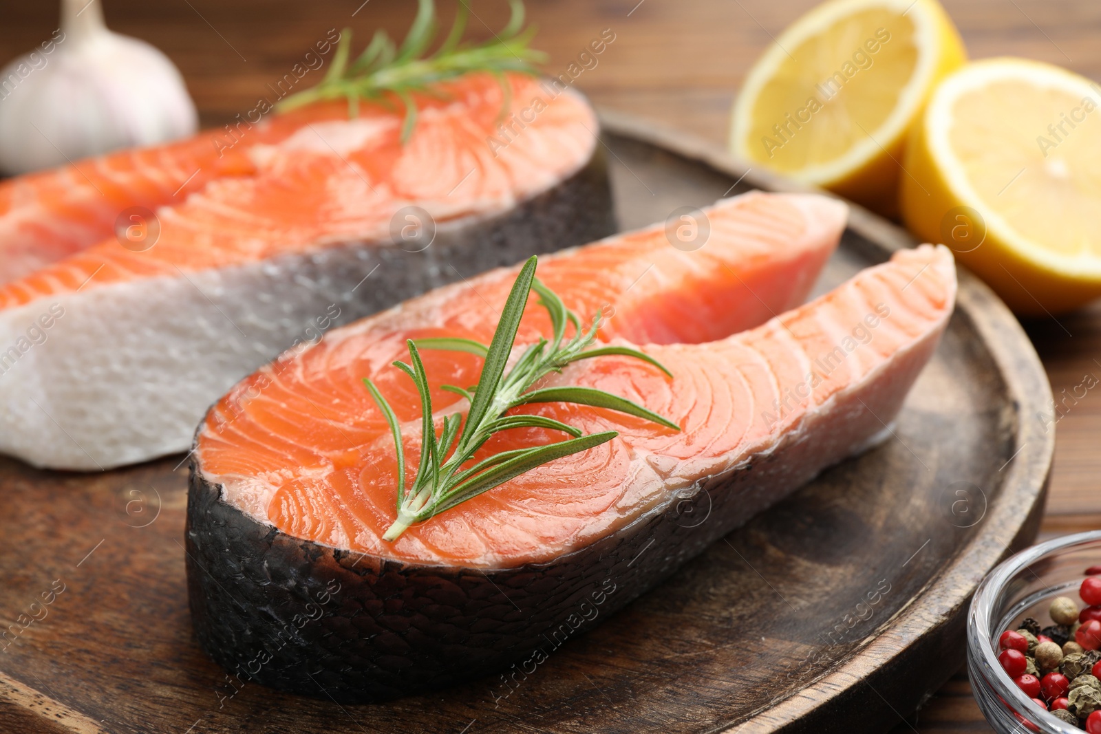 Photo of Fresh raw salmon steaks and spices on table, closeup