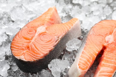 Photo of Fresh raw salmon steaks on ice pieces, closeup