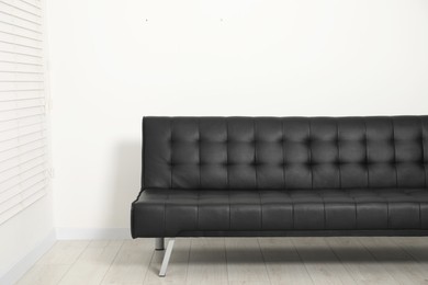 Photo of Comfortable couch near white wall. Interior design