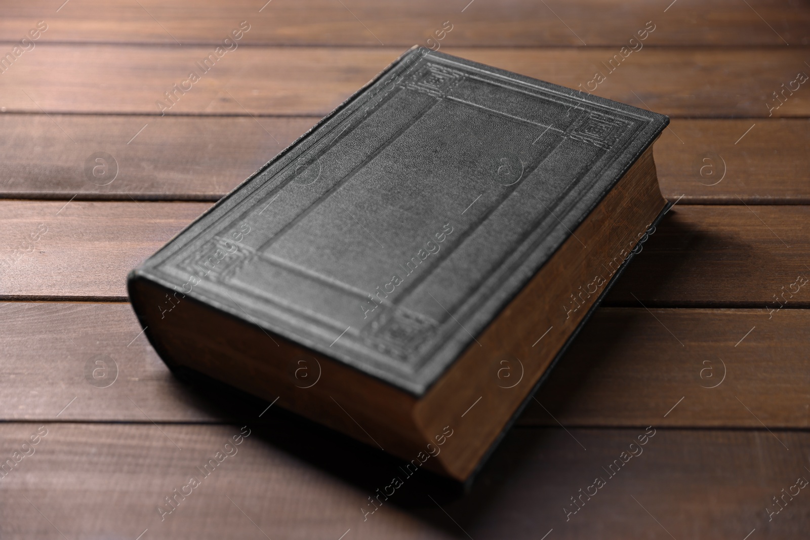 Photo of Closed Bible on wooden table. Christian faith