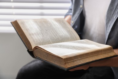 Photo of Man with Bible indoors, closeup. Christian faith