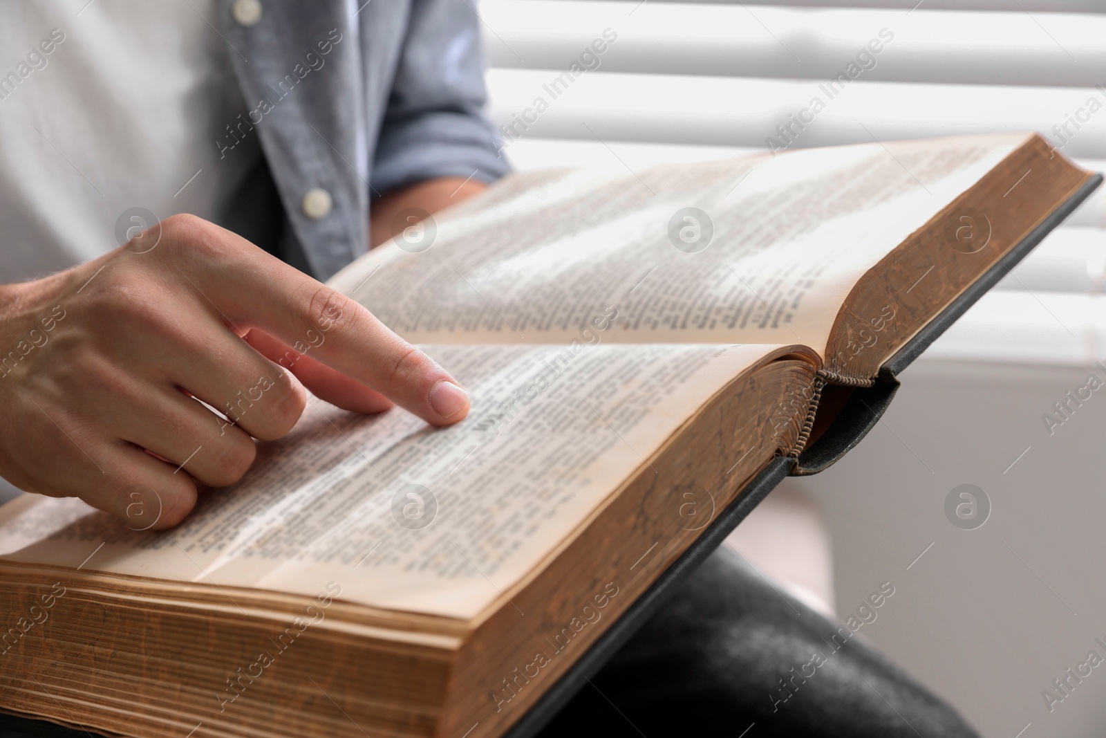 Photo of Man with Bible indoors, closeup. Christian faith