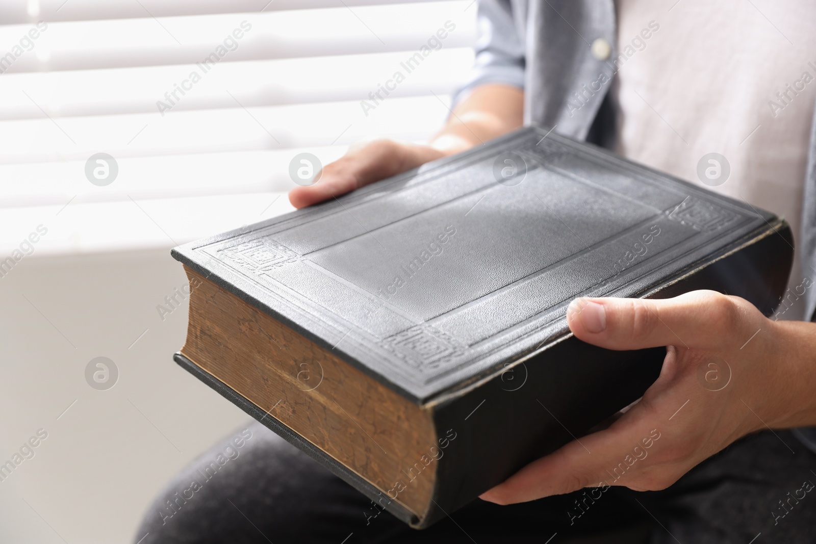 Photo of Man with Bible indoors, closeup. Christian faith