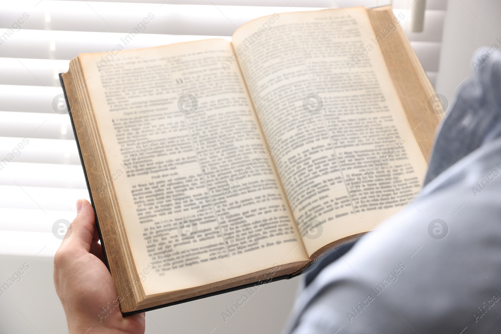 Photo of Man with Bible indoors, closeup. Christian faith