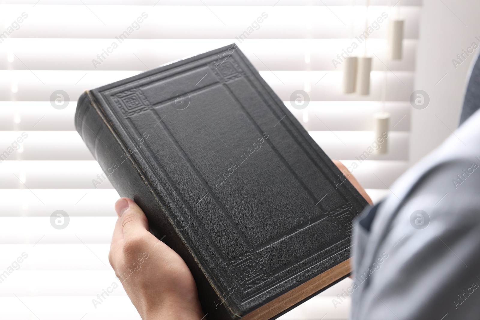 Photo of Man with Bible indoors, closeup. Christian faith