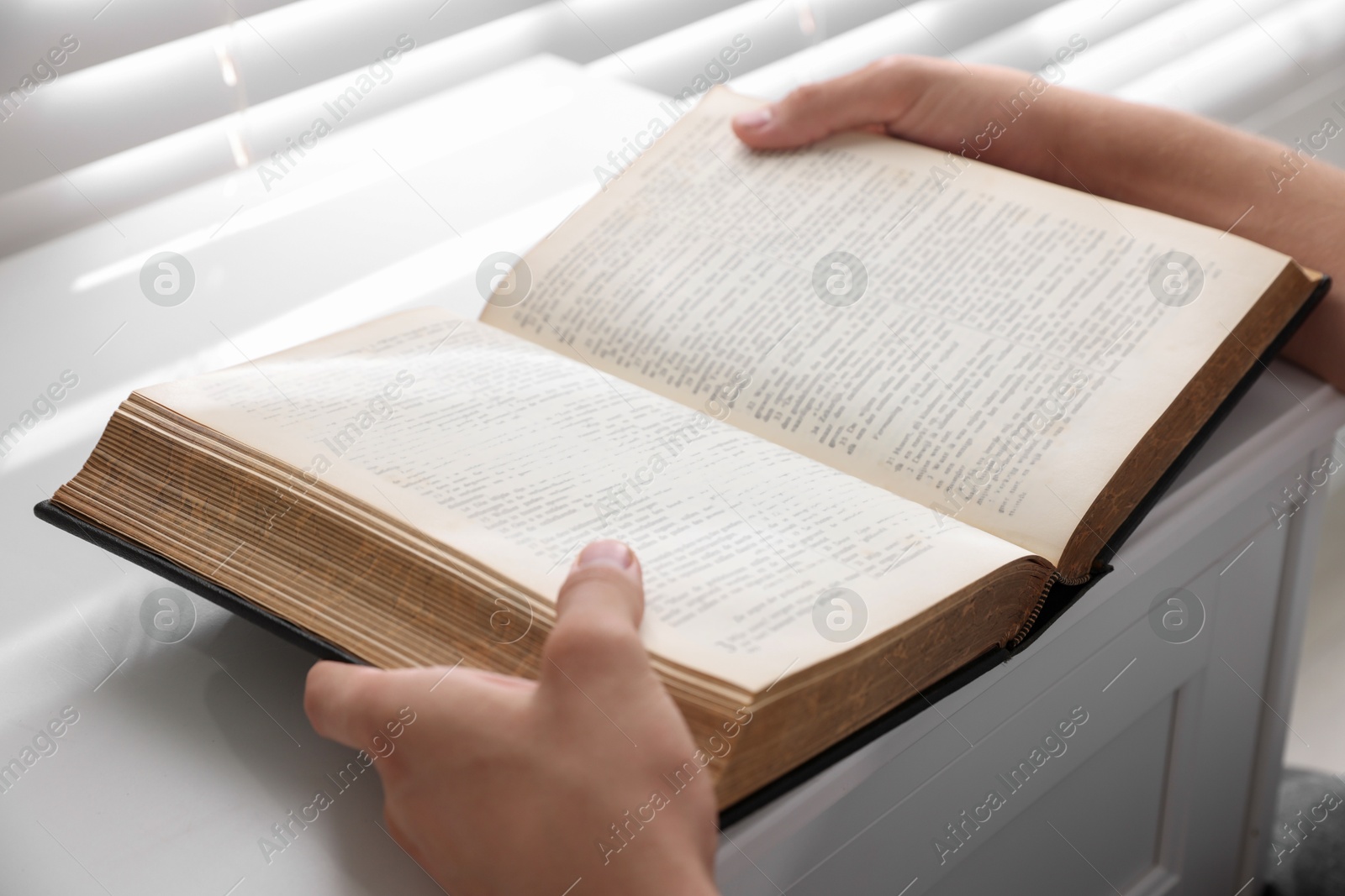 Photo of Man with Bible at white table, closeup