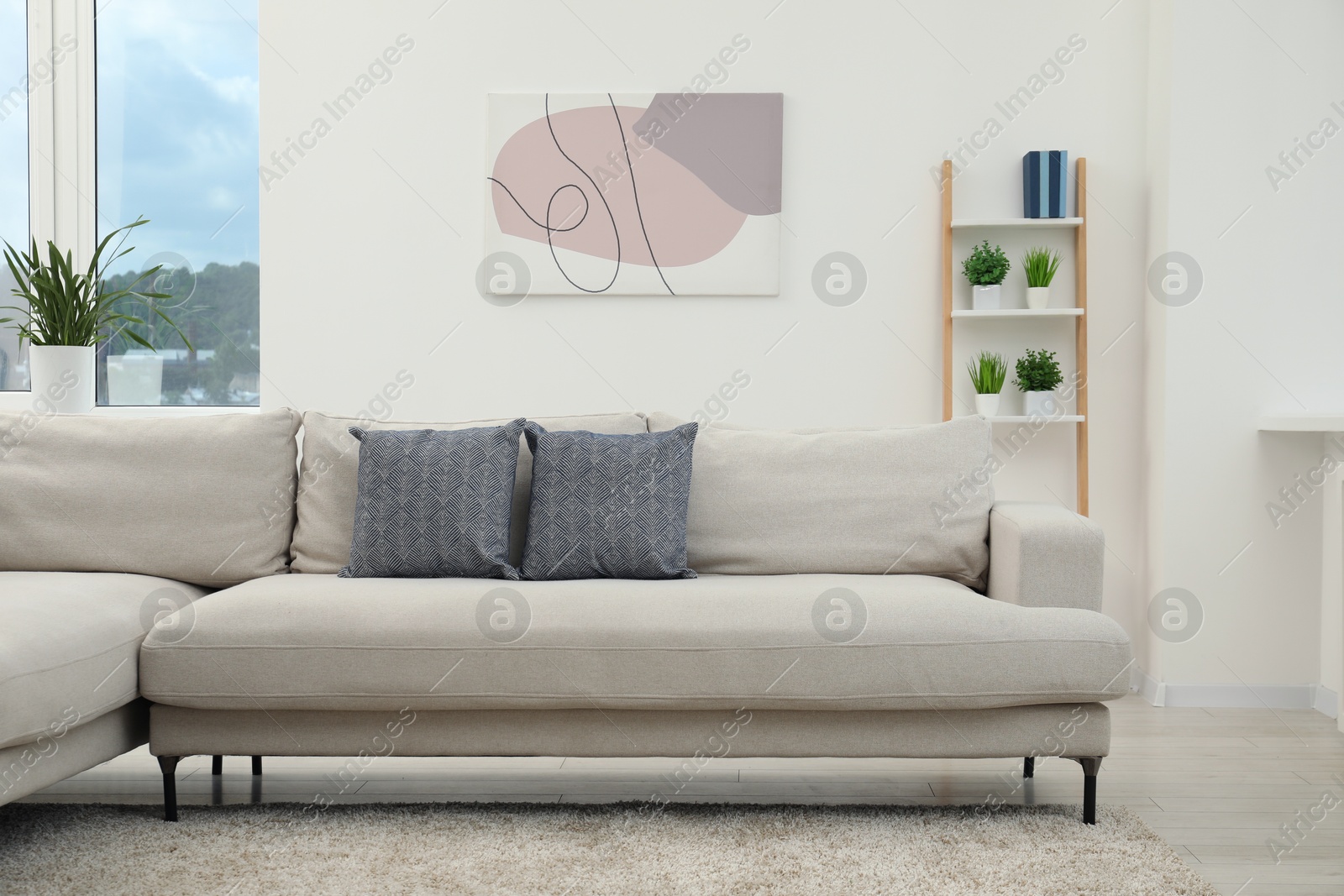 Photo of Stylish room interior with comfortable sofa and houseplants