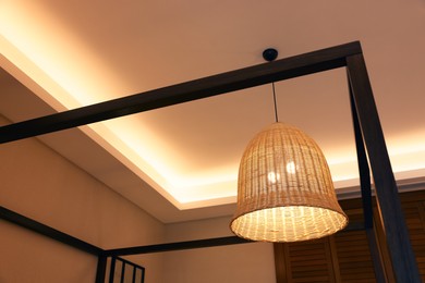 Stylish pendant lamp on ceiling indoors, low angle view