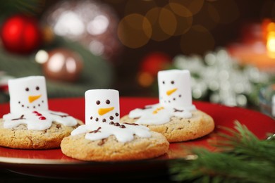 Photo of Funny marshmallow snowmen and cookies on table, closeup