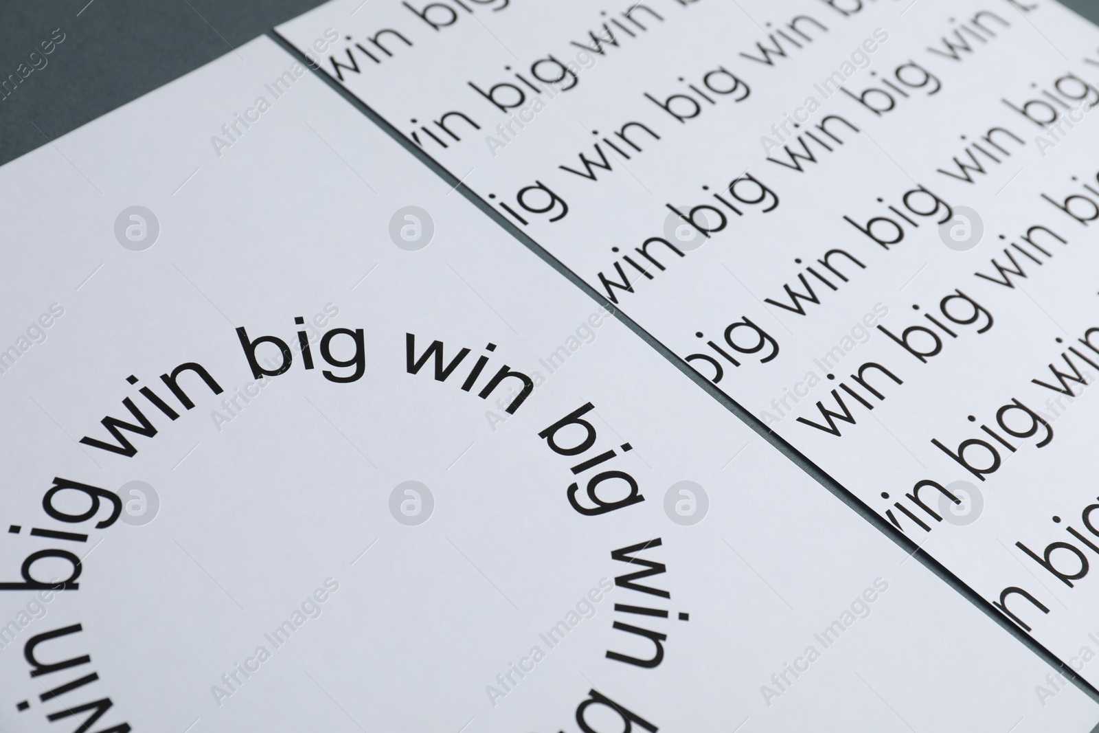 Photo of Sheets of paper with words Big win on grey table, closeup