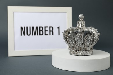 Photo of Frame with phrase Number 1 and silver crown on grey background