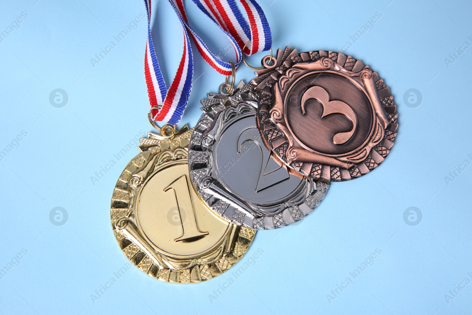 Photo of Different medals on light blue background, flat lay