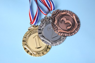 Photo of Different medals on light blue background, flat lay