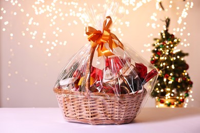 Photo of Wicker gift basket with wine on white table