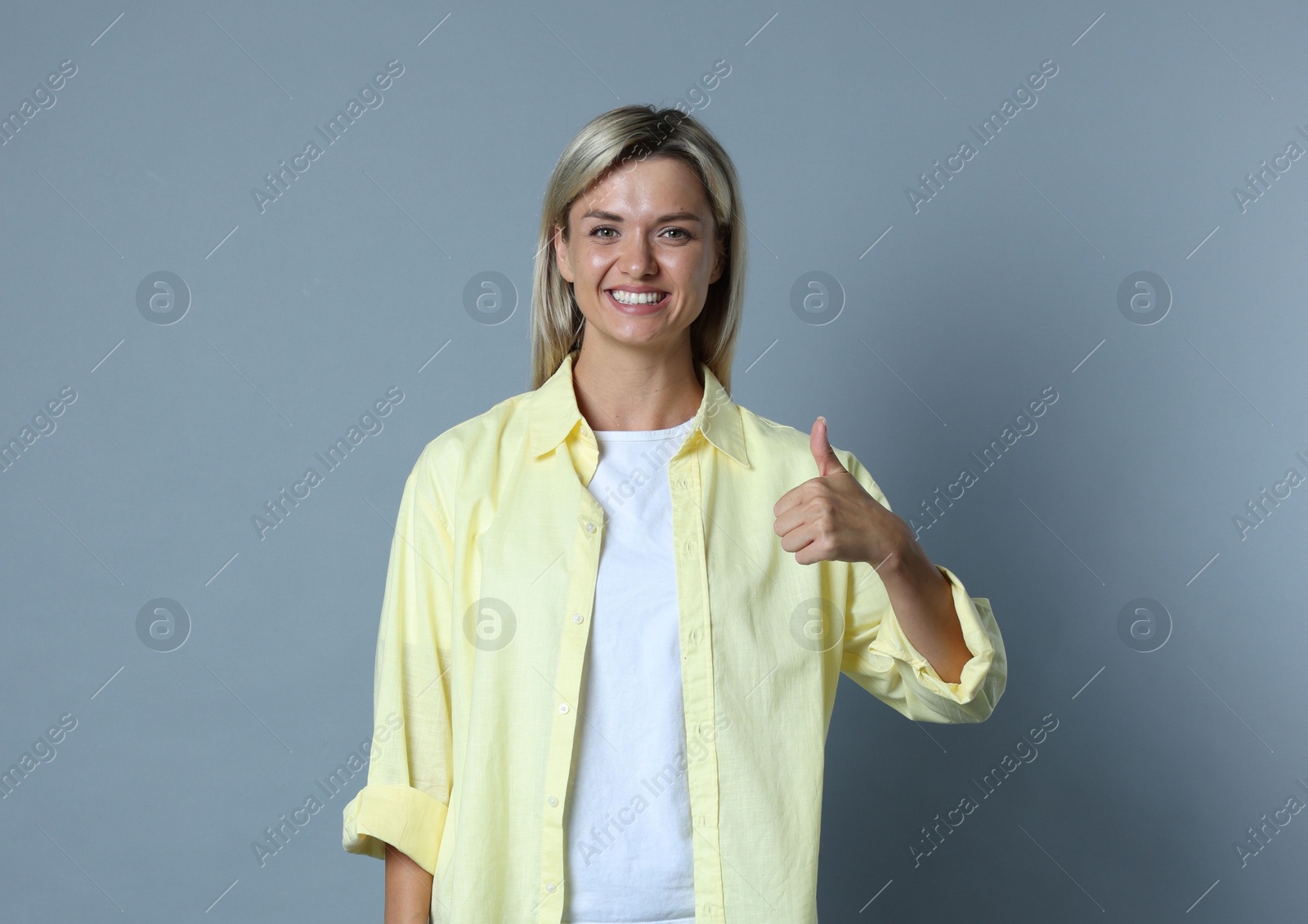 Photo of Happy winner showing thumbs up on gray background