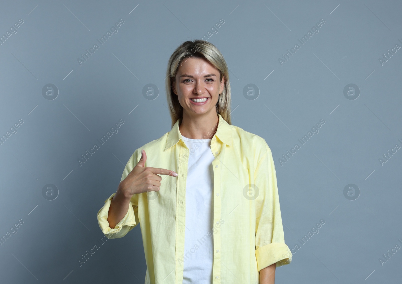 Photo of Happy winner pointing at something on gray background