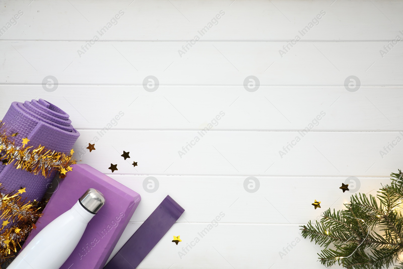 Photo of Flat lay composition with yoga mat and Christmas decor on white wooden background, space for text