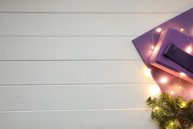 Photo of Flat lay composition with yoga mat and Christmas decor on white wooden background, space for text