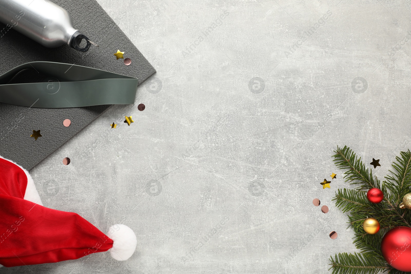 Photo of Flat lay composition with yoga mat and Christmas decor on gray textured background, space for text