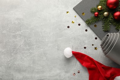 Photo of Flat lay composition with yoga mat and Christmas decor on gray textured background, space for text