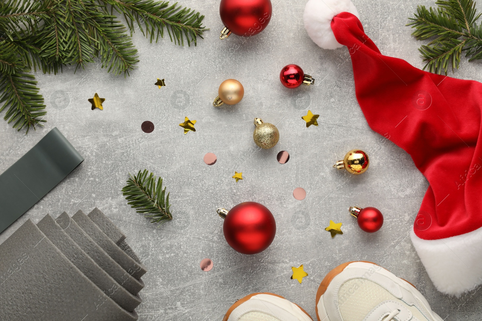 Photo of Flat lay composition with yoga mat and Christmas decor on gray textured background