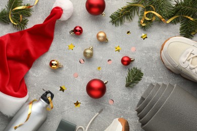 Photo of Flat lay composition with yoga mat and Christmas decor on gray textured background