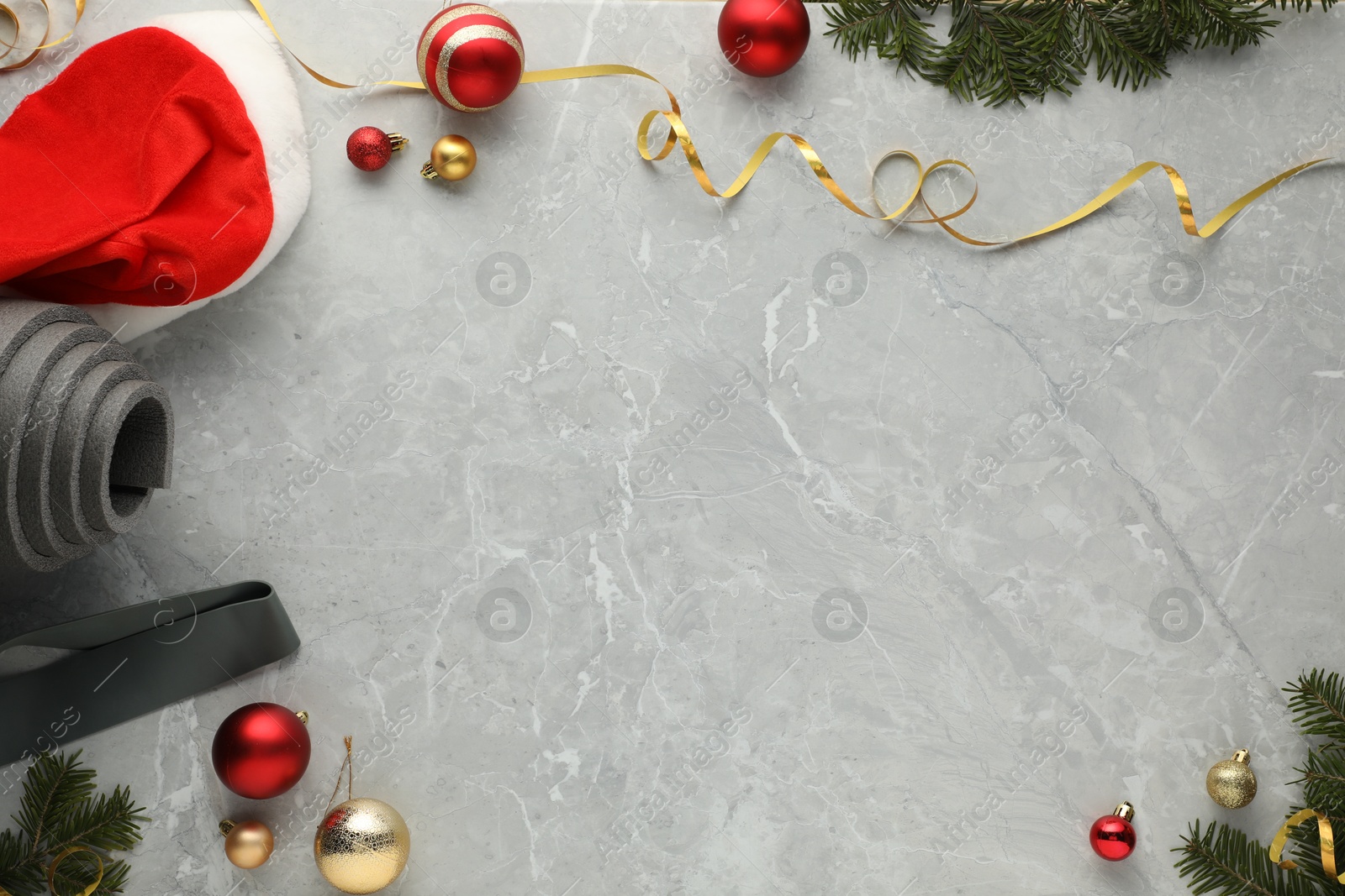 Photo of Flat lay composition with yoga mat and Christmas decor on gray textured background, space for text