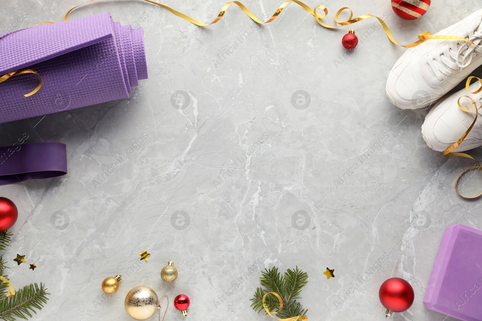 Photo of Flat lay composition with yoga mat and Christmas decor on gray textured background, space for text