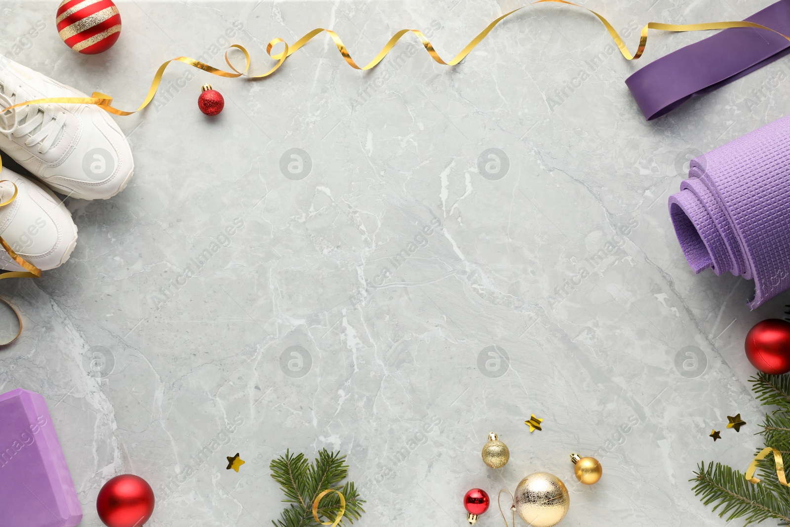 Photo of Flat lay composition with yoga mat and Christmas decor on gray textured background, space for text