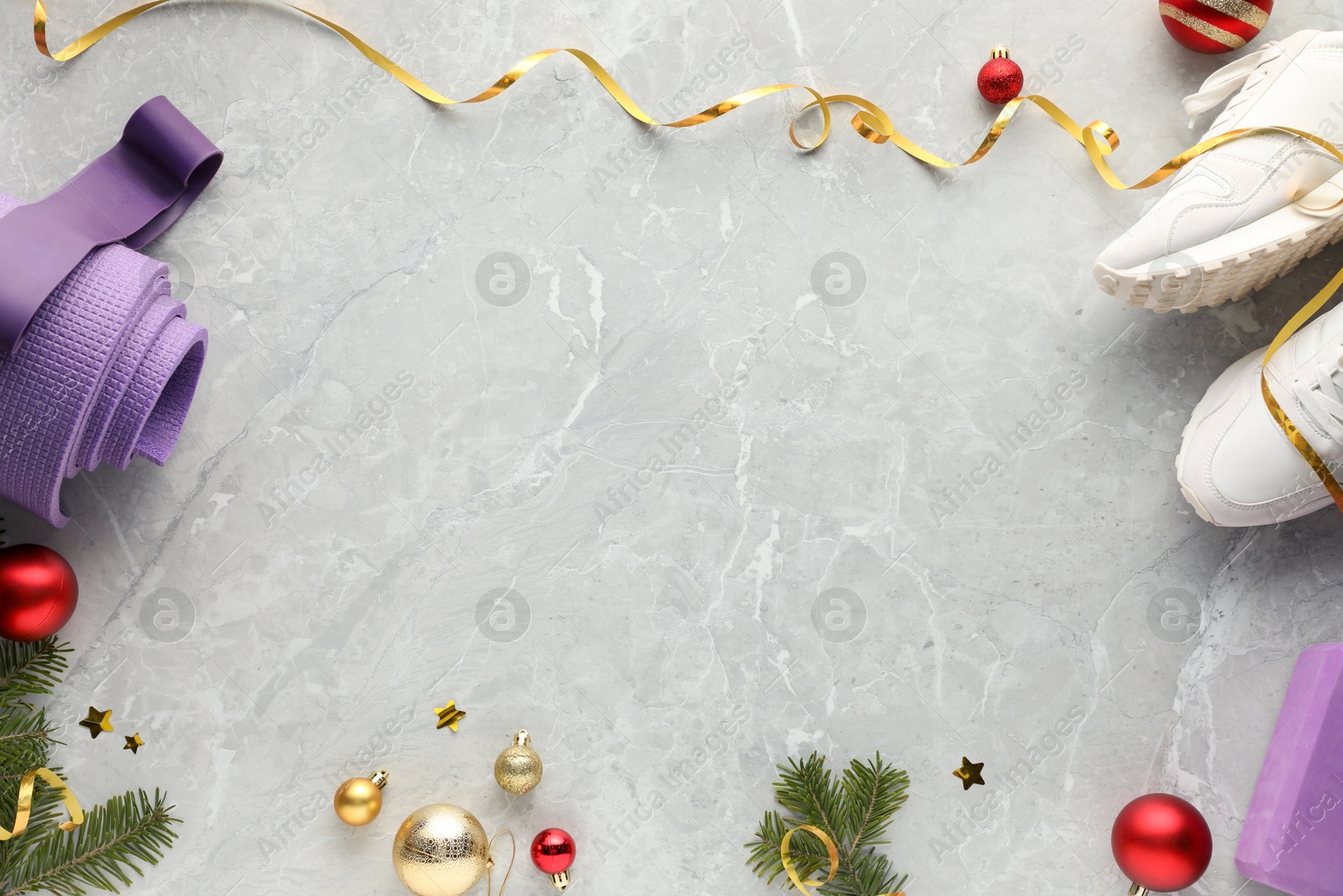 Photo of Flat lay composition with yoga mat and Christmas decor on gray textured background, space for text