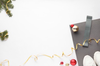 Photo of Flat lay composition with yoga mat and Christmas decor on white background, space for text