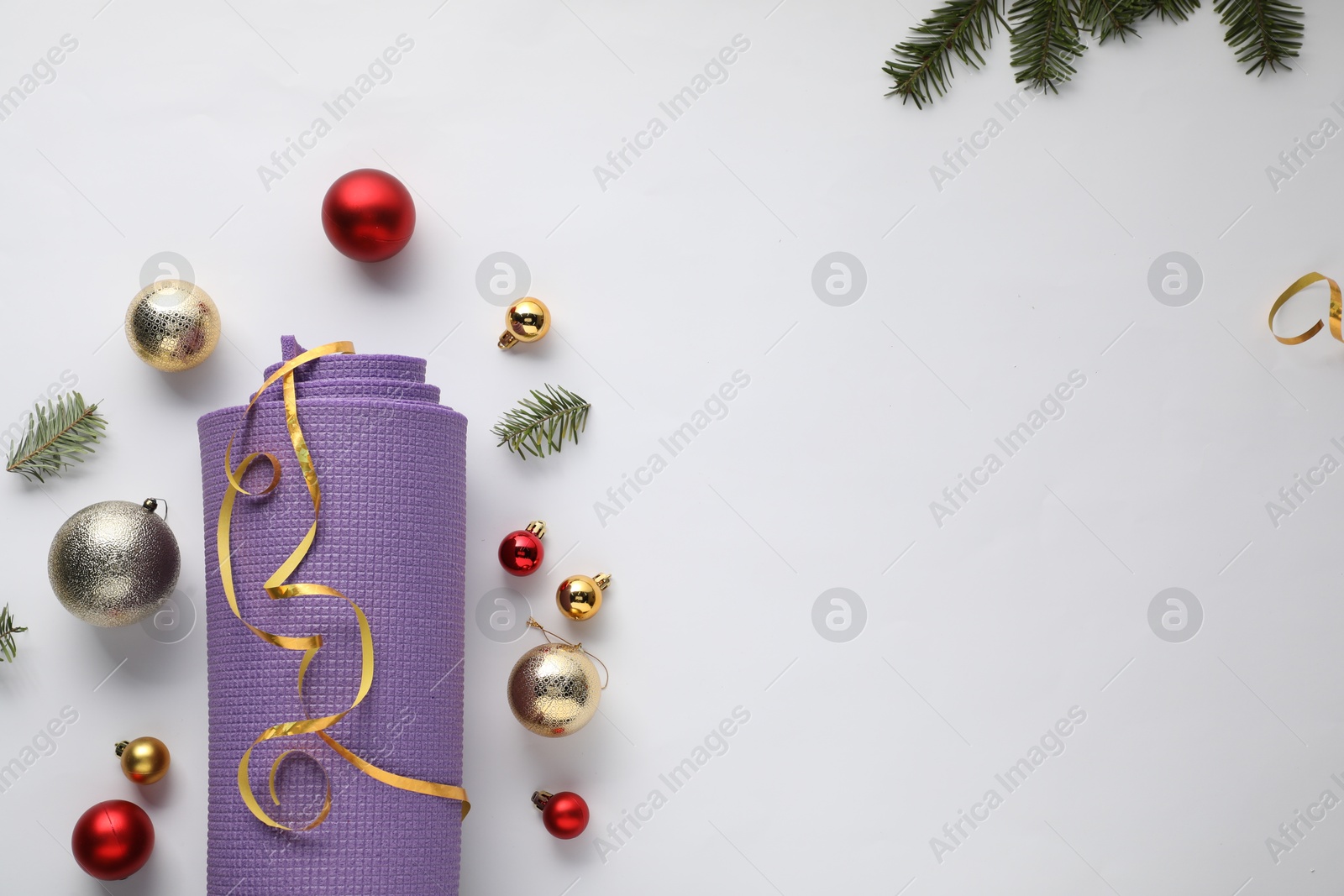 Photo of Yoga mat and Christmas decor on white background, flat lay. Space for text