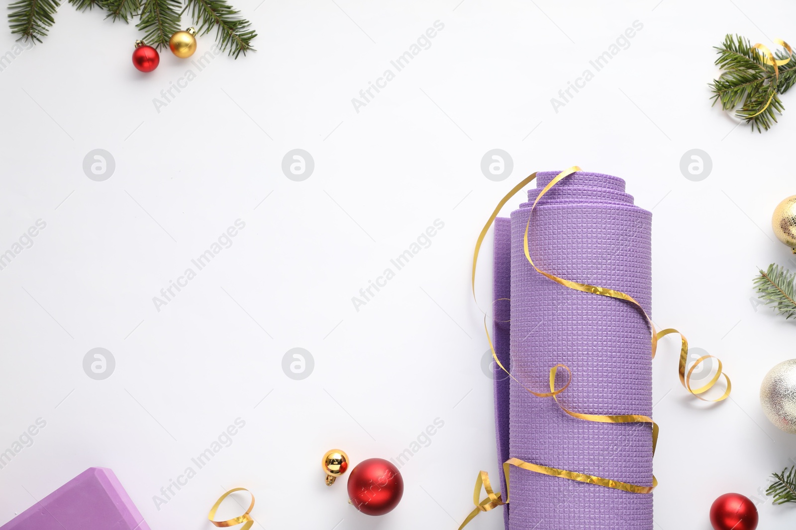 Photo of Yoga mat and Christmas decor on white background, flat lay. Space for text