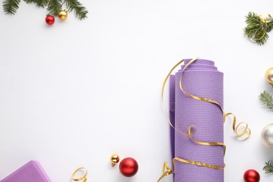 Photo of Yoga mat and Christmas decor on white background, flat lay. Space for text