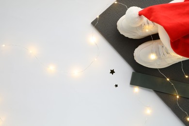 Photo of Yoga mat, sneakers, Santa hat, band and Christmas decor on white background, top view