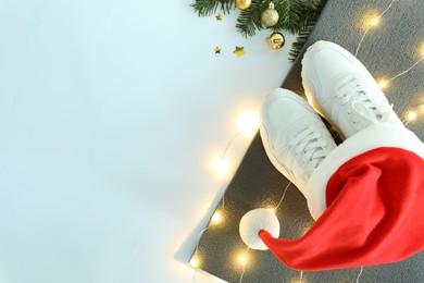 Photo of Yoga mat, sneakers, Santa hat and Christmas decor on white background, flat lay. Space for text