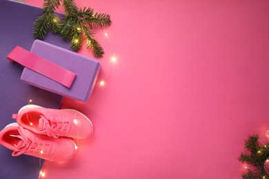 Photo of Flat lay composition with yoga mat and Christmas decor on pink background, space for text