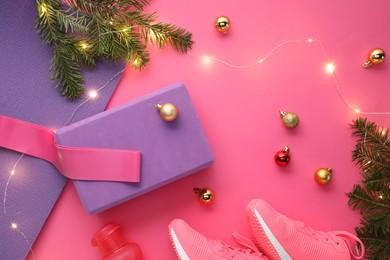 Photo of Flat lay composition with yoga mat and Christmas decor on pink background