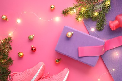 Photo of Flat lay composition with yoga mat and Christmas decor on pink background