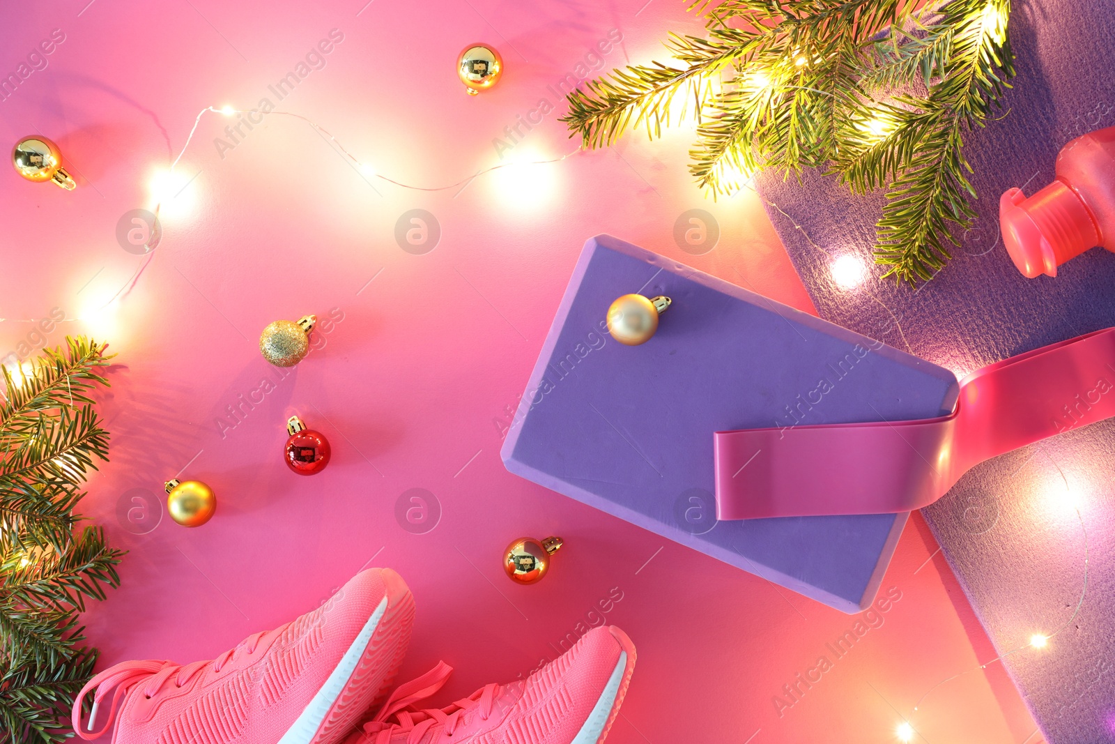 Photo of Flat lay composition with yoga mat and Christmas decor on pink background