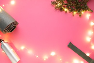 Photo of Yoga mat, band, bottle and Christmas decor on pink background, flat lay. Space for text